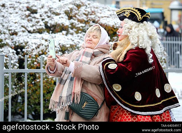 RUSSIA, ST PETERSBURG - OCTOBER 28, 2023: A woman makes a selfie with a street performer. Valentin Yegorshin/TASS