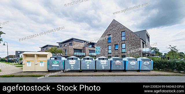 05 August 2023, Schleswig-Holstein, Bargtheide: Recycling containers for glass, paper and used clothing are located in a new development