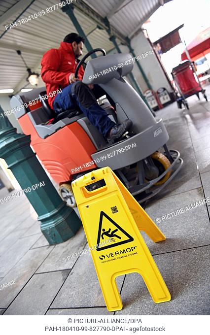 10 April 2018, Germany, Munich: An employee of the cleaning service of the German Railway cleans the floor at the Pasing train station