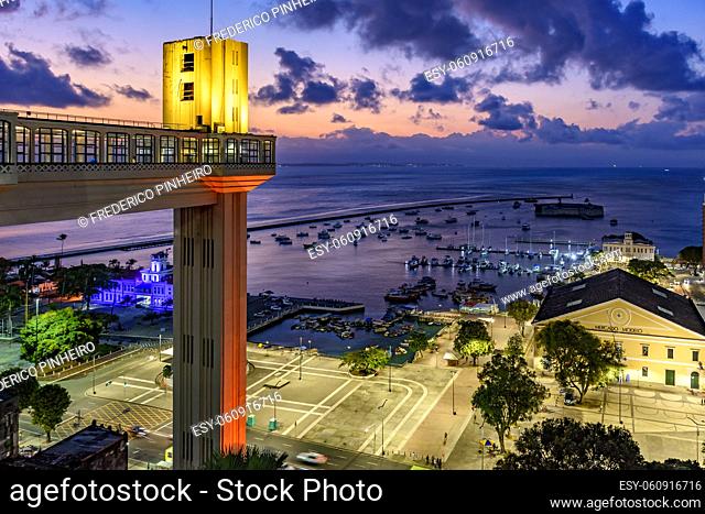 Lacerda elevator illuminated at dusk and with the sea and boats in the background in the city of Salvador, Bahia