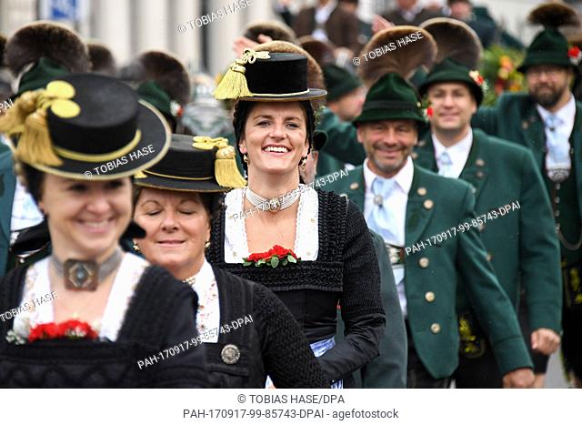 People in traditional attire walk across the Ludwigstrasse (street) during the costume parade in Munich, Germany, 17 September 2017