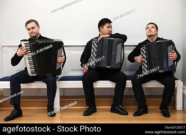 RUSSIA, NOVOSIBIRSK - JUNE 28, 2023: Kirill Kush, Konstantin Davydov and Matvei Starodubtsev (L-R) of the Novosibirsk State Conservatory bayan quartet prepare...