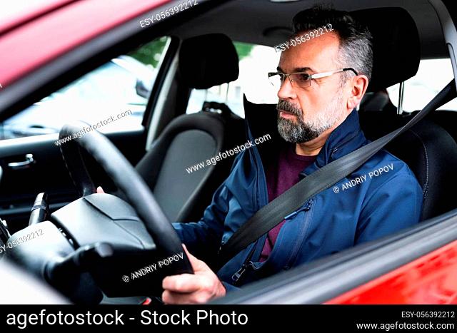 Senior Man Holding Steering Wheel While Driving Car
