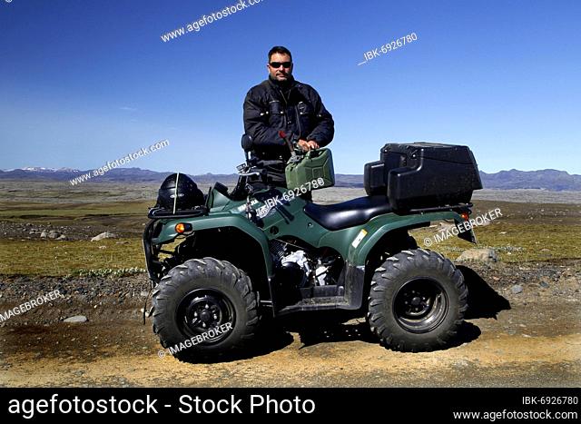 Track, ATV, Yamaha Grizzly, biker, quad rider fills up with gasoline, gas can, lava landscape, laki fissure, highlands, Iceland, Europe