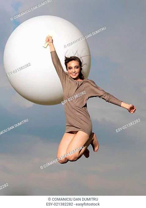 happy woman jumping with big, white balloon