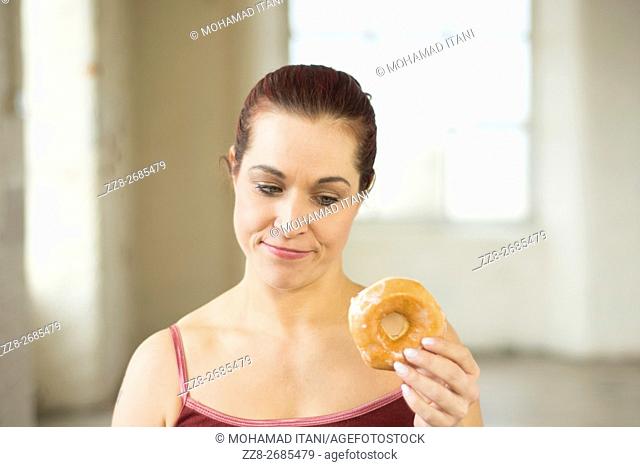 Woman feeling guilty eating donuts
