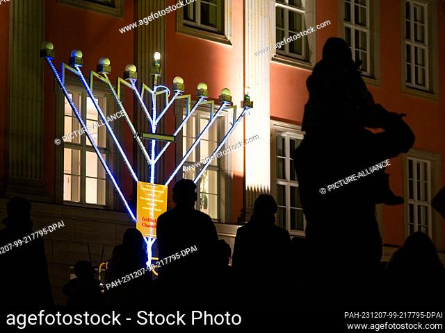 07 December 2023, Brandenburg, Potsdam: Members of the Jewish community stand in front of the Hanukkah candelabra in front of the Brandenburg State Parliament