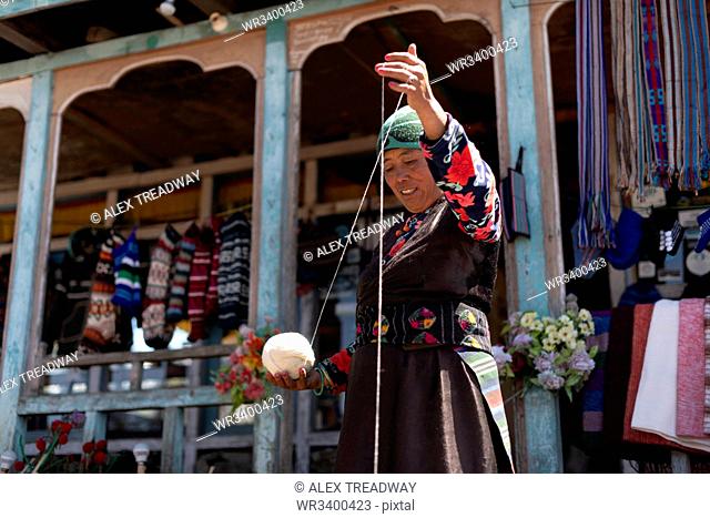 A Sherpa woman from Gosainkund spins baby Yak wool using the traditional method with a spindle, Langtang region, Nepal, Asia