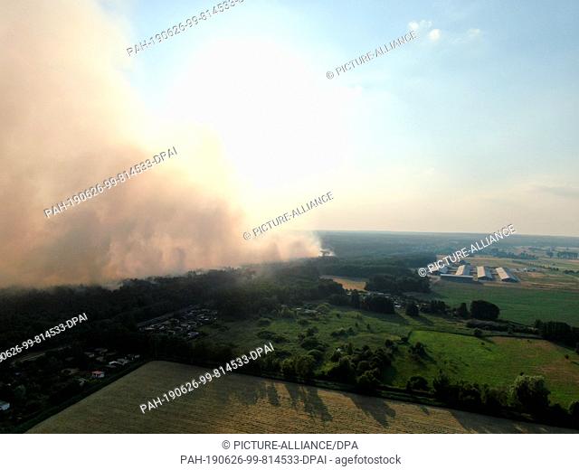 26 June 2019, Germany (German), Ziltendorf: Smoke from a fire rises above the forest between Wiesenau and Ziltendorf. The forest fire has broken out in the...