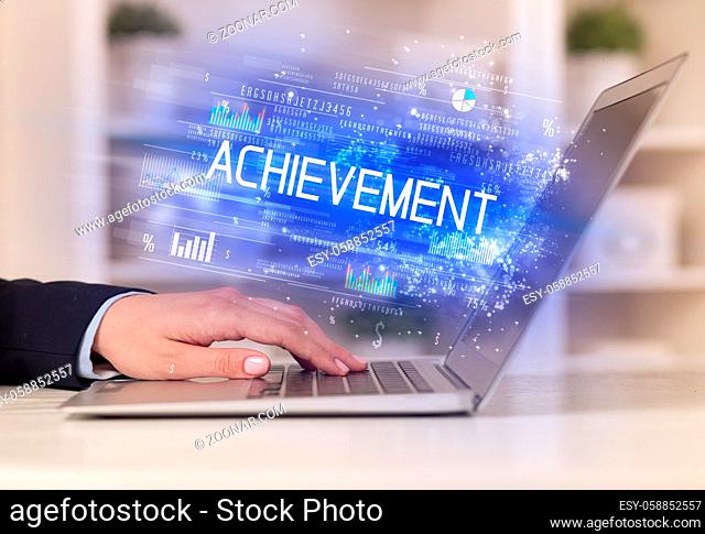 Closeup of businessman hands working on laptop with ACHIEVEMENT inscription, succesfull business concept