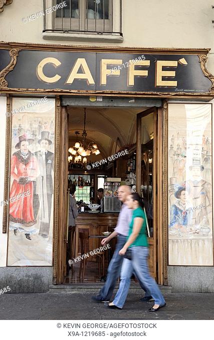 Two people passing outside Cafe Vittorio Veneto in Vittorio Veneto Square in Turin, Italy