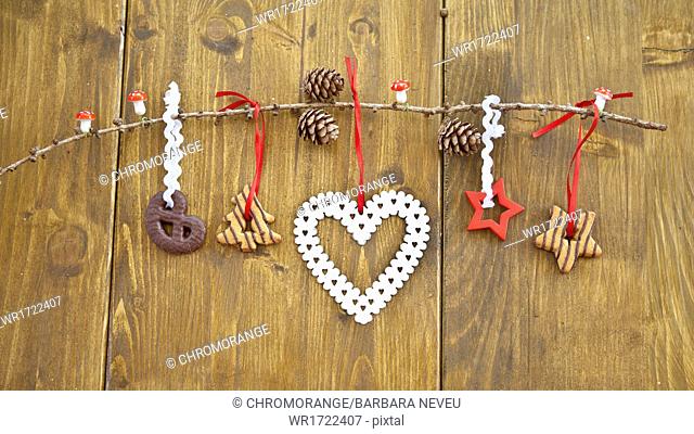 Wooden branch with christmas cookies and ornaments
