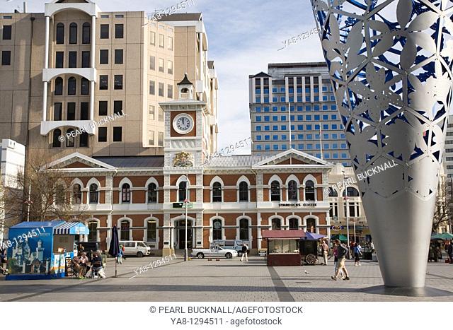 Christchurch Canterbury South Island New Zealand  Old Post Office clock tower in Cathedral Square in city centre with The Chalice modern steel sculpture by Neil...