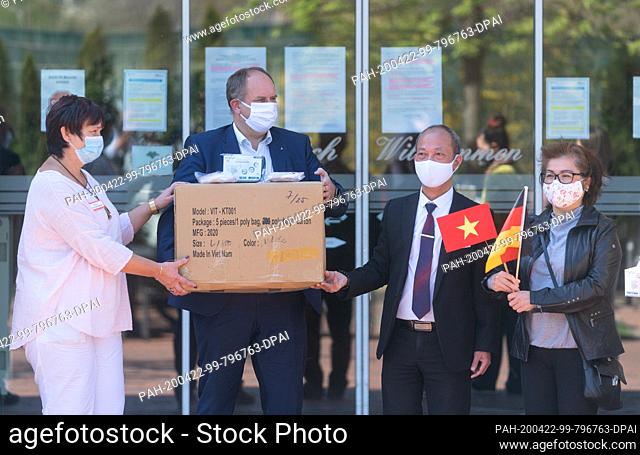 22 April 2020, Saxony, Dresden: The coordinator of the mask donation Nguyen Ngoc (2nd from right) and Dang Bich Lan, (r) chairman of the Vietnamese Women's Club...