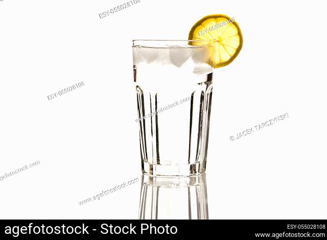 glass of mineral water with lemon and ice isolated on white