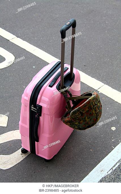 Pink suitcase with a combat helmet of the German armed forces, Germany, Europe