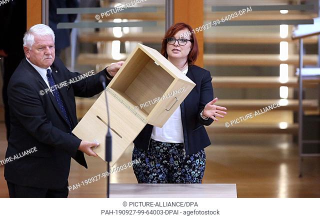 27 September 2019, Saxony-Anhalt, Magdeburg: Lydia Funke (AfD, r), member of the state parliament, and an usher present an empty ballot box in the state...