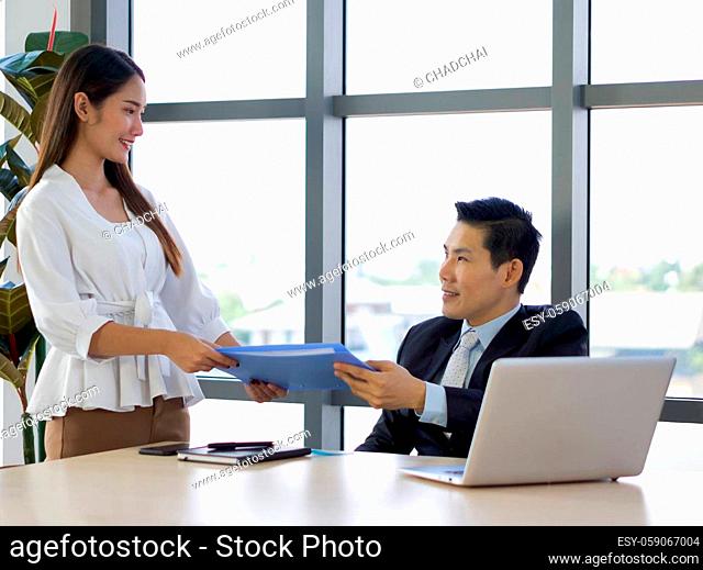 Managing Director in suit returns document folder to secretary with an impression after the project was completed