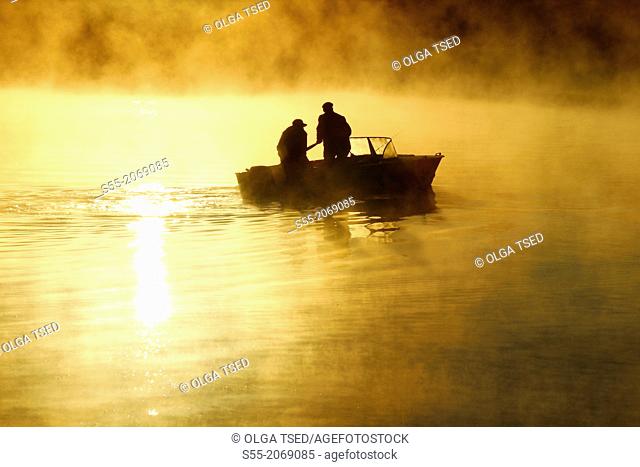 Two fishermen in the Finnish Gulf, sunrise. Primorsk, Russia