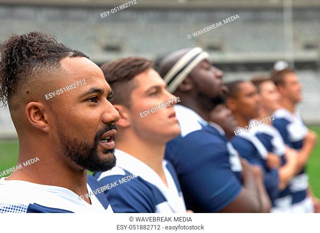 Group of diverse male rugby players taking pledge together in stadium