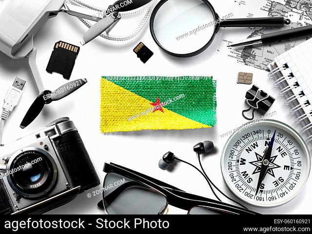 Flag of French Guiana and travel accessories on a white background. The view from the top