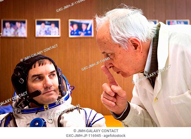 Spacesuit designer Oleg Gerasimenko shares some tips on the Sokol spacesuit with NASA astronaut Rex Walheim, STS-135 mission specialist