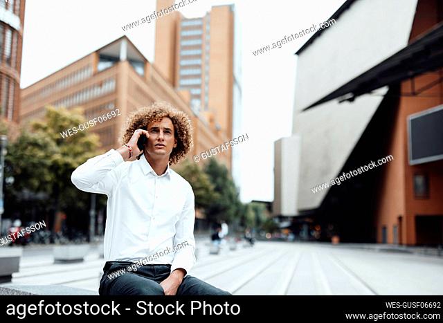 Businessman talking on mobile phone in city