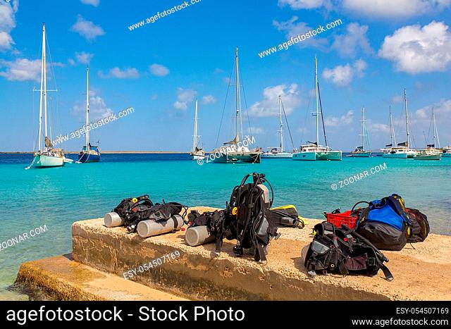 Diving equipment on coast of Bonaire with sailing boats on sea