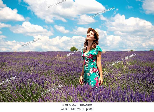 France, Provence, Valensole plateau, happy woman with straw hat standning in lavender field