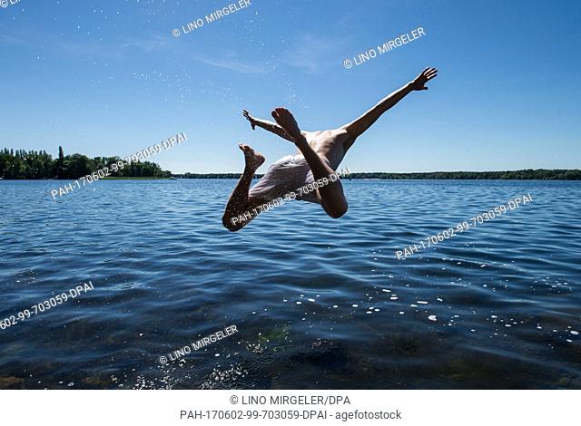 Corvin Merten (25) jumps into the Tegeler See lake in Berlin, Germany, 2 June 2017. Photo: Lino Mirgeler/dpa. - Berlin/Berlin/Germany