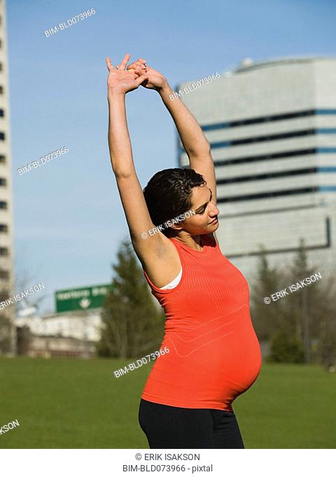 Pregnant Middle Eastern woman stretching