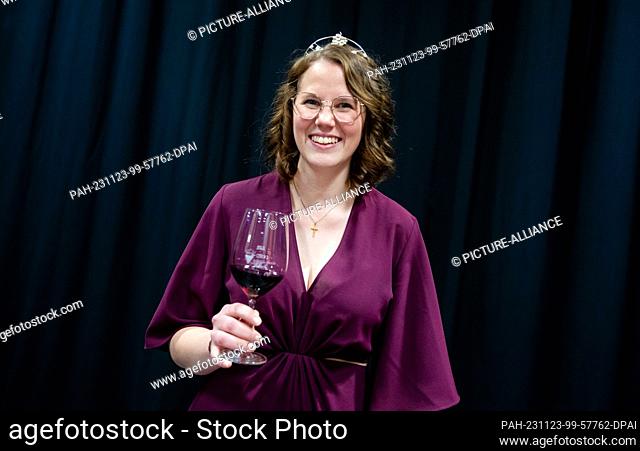 23 November 2023, Baden-Württemberg, Massenbachhausen: Larissa Salcher raises a glass of red wine as the 58th Württemberg Wine Queen