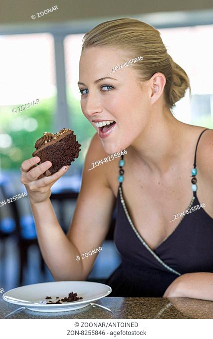Young blond woman enjoying chocolate cake