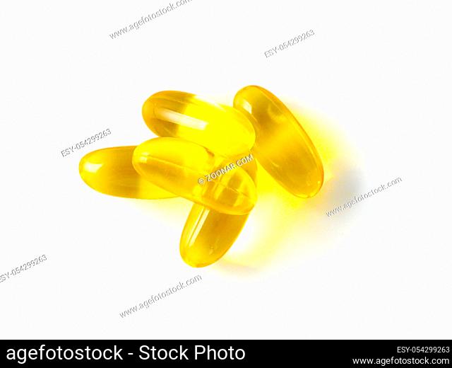 Omega 3 fish oil capsules isolated on white background. Golden color capsules - vitamin E, D or multivitamin