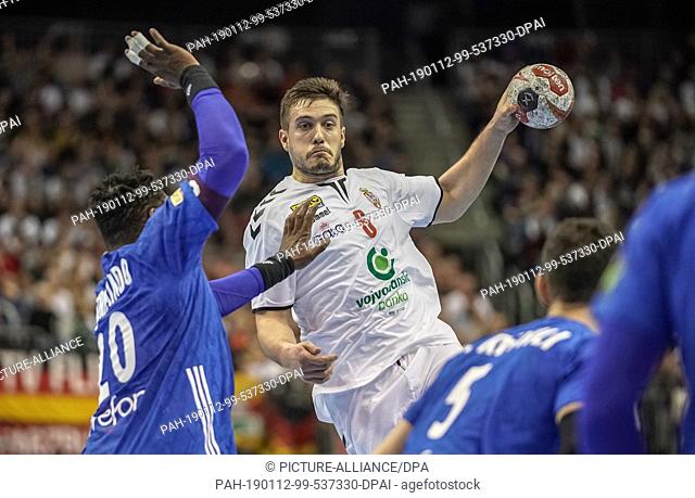 12 January 2019, Berlin: Handball: WM, France - Serbia, preliminary round, group A, 2nd matchday. Milos Orbovic from Serbia throws between Cedric Sorhaindo (l)...