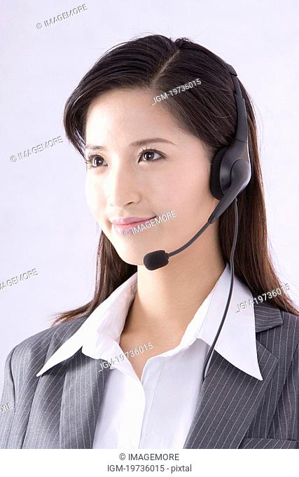 Young businesswoman using cell phone, smiling, looking at camera
