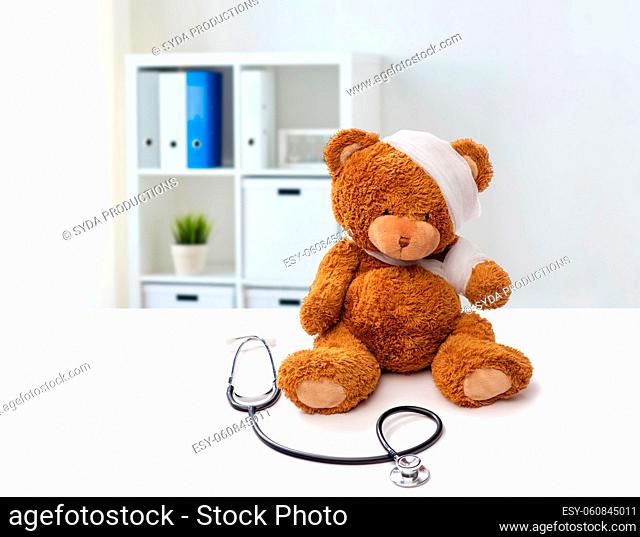 bandaged teddy bear toy with stethoscope at clinic