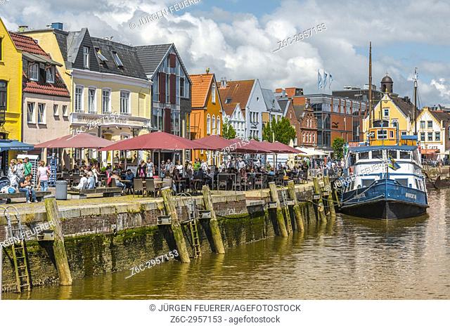 pavement café and fish restaurants at the pier, inner harbour of the coastal town Husum at the North Sea, Germany