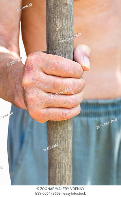 peasant holds old wooden tool handle