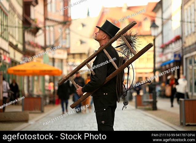 10 November 2021, Saxony-Anhalt, Wernigerode: A chimney sweep is on duty in a pedestrian zone. The happiest people in Germany live in Saxony-Anhalt and...
