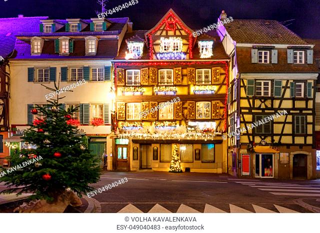 Traditional Alsatian half-timbered houses in old town of Colmar, decorated and illuminated at snowy christmas night, Alsace, France