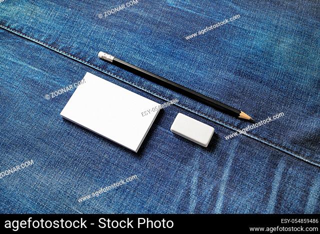 Blank stationery set. White business cards, pencil and eraser on denim background