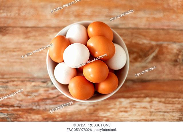 close up of eggs in ceramic bowl on wooden table