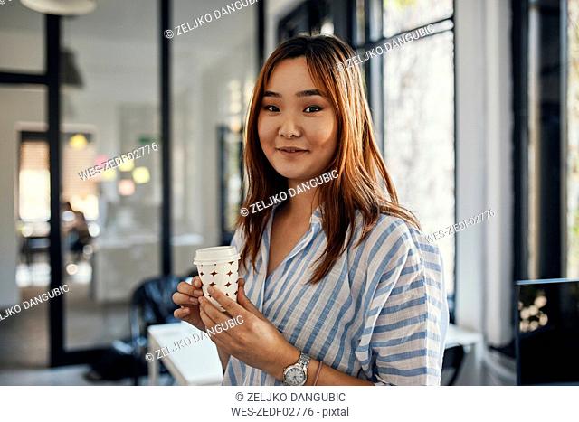 Portrait of businesswoman having a coffee break in office