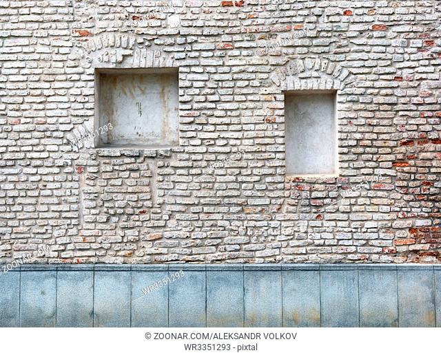 Blind curved basement windows in the old aged red bricks house outdoor background