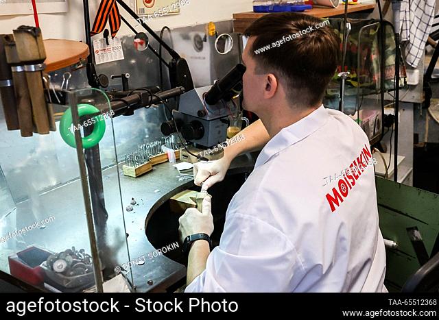 RUSSIA, YEKATERINBURG - DECEMBER 6, 2023: A worker employs the Russkaya Zakrepka stone setting technique to inlay an item with tsavorite at the Moiseikin...