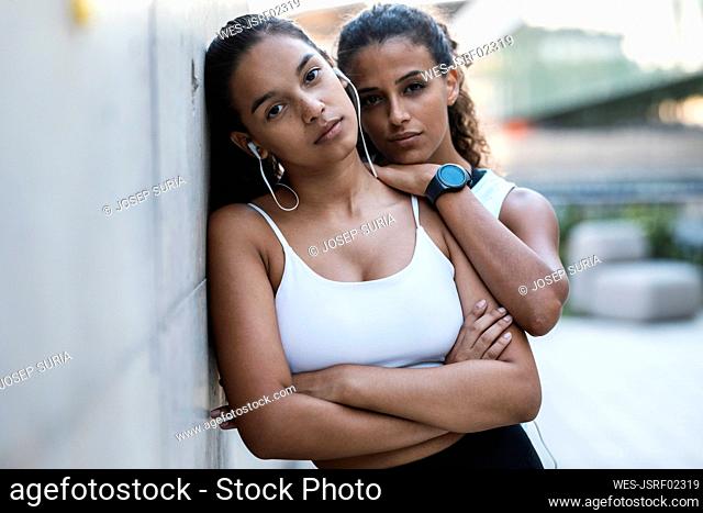 Teenage girl leaning on wall with friend
