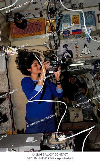 Astronaut Sunita L. Williams, Expedition 1415 flight engineer, sets up a video camera in the Zvezda Service Module of the International Space Station