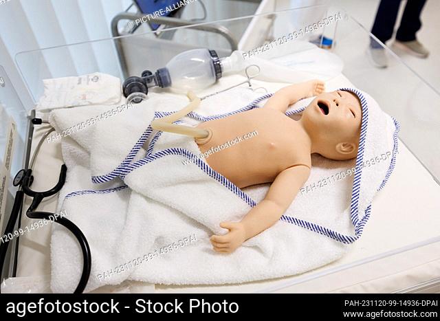 20 November 2023, Lower Saxony, Osnabrück: The dummy of an infant lies in a bed in the simulation laboratory of the Midwifery Science course at Osnabrück...