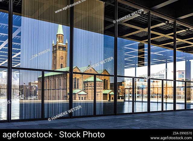 Berlin, Germany - March 19, 2022: Saint Matthew's Church in the reflection of the Neue Nationalgalerie, Museum of Classical Modernism